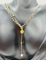 Model wearing an asymmetrical pearl and gold chain drop necklace in the UAE.