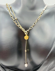 Model wearing an asymmetrical pearl and gold chain drop necklace in the UAE.
