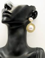 Pearl and gold earrings on a mannequin head