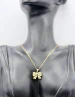 Waterproof gold ribbon bow pendant necklace on silk Dubai.
