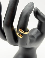 Gold ring on a black mannequin hand against a white background