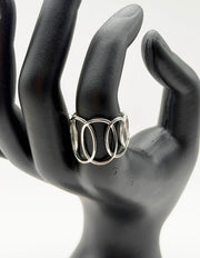 Silver ring on a black mannequin hand against a white background