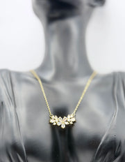 Waterproof gold diamond style flower necklace on white silk.