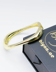 Gold bracelet on a black box with 'biyaa.ae' branding