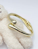Non-tarnish sculptural wrap statement bangle for women Dubai luxury fashion.