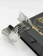 Metallic bangle on a black box with 'Biyaa.ae' branding.