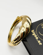 Non-tarnish thick twisted gold statement bangle for women Dubai luxury fashion.