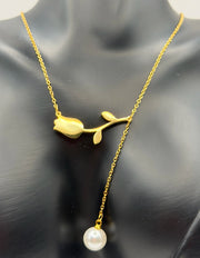 Model wearing an elegant gold lariat drop necklace with pearls in the UAE.