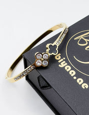 18K gold plated black onyx and crystal clover bypass bangle by Biya Accessoires.