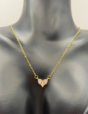Gold necklace with a heart-shaped pendant on a mannequin.