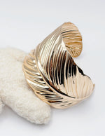 Non-tarnish wide gold feather bangle for women Dubai luxury fashion.