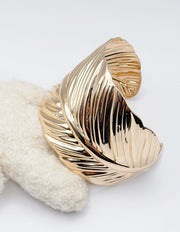 Non-tarnish wide gold feather bangle for women Dubai luxury fashion.