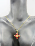 Gold necklace with a red flower pendant on a mannequin