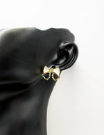 Everyday luxury fashion jewelry gold tone statement bow studs by Biya Accessoires Dubai.