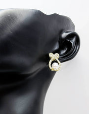 Sparkling crystal bow earrings with a luminous faux pearl center.