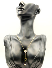 Waterproof gold Y-necklace with black and white floral pendants.