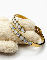 Hypoallergenic non-tarnish high polish gold rigid geometric bangle with pave crystals.