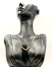 Waterproof gold geometric pavé pendant on white display.