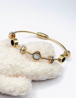 Biya Accessoires gold twisted cable wire bangle with roman numeral charms.
