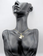 Waterproof non-tarnish gold heart jewelry resting on white silk fabric.
