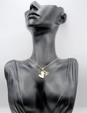 Waterproof non-tarnish gold heart jewelry resting on white silk fabric.