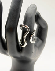 Silver ring on a black mannequin hand against a white background