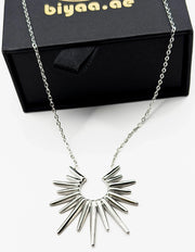 Edgy silver statement necklace with radiant spikes on display.