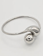 Silver bangle bracelet paired with dainty gold bar necklace