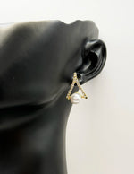 Aesthetic jewelry uae pearl studs nestled in a crystal arch by biyaa jewelry UAE.