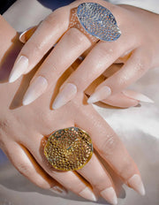 Close-up of a hand wearing two decorative rings with a soft background