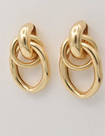 Close-up of linked oval gold dangle earrings