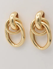 Close-up of linked oval gold dangle earrings